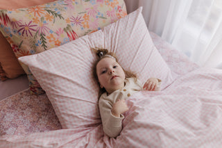 Little girl with disability lying on a pillow in a bed