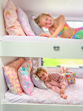 two children smiling on bunk beds